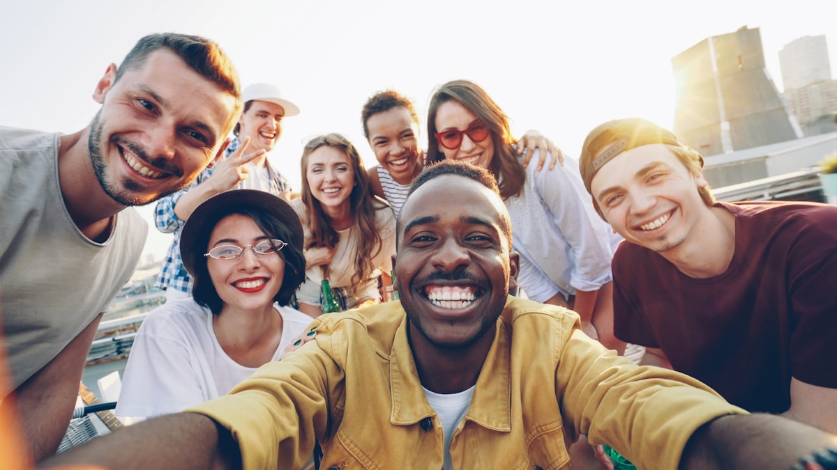 Groupe multiethnique d'adultes souriant ensemble en extérieur
